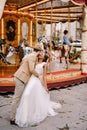 Wedding in Florence, Italy. Multiethnic wedding couple. African-American bride and Caucasian groom near the carousel. Royalty Free Stock Photo