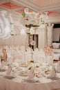 Wedding flowers decoration in the restaurant. Banquet round tables, decorated with a bouquet of white flowers in the center of the