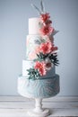 Wedding four-tiered cake decorated with spring red flowers and handmade pattern. Concept of delicious desserts Royalty Free Stock Photo
