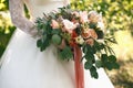 Wedding gentle disheveled bouquet of peach shades with pink ribbon