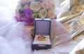 Wedding gold rings in a box on a golden fabric with a veil and bouquet of flowers. Luxury. Royalty Free Stock Photo
