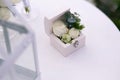 Wedding gold rings decorated with flowers on a white background in a wooden box on the table for a wedding ceremony Royalty Free Stock Photo