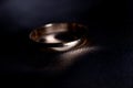 Wedding golden ring closeup on dark background.