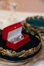 Wedding golden rings bands in a red velvet box in the center of a golden crown. Royalty Free Stock Photo