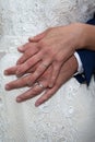Wedding golden rings fingers bride and groom hands on marriage white dress background Royalty Free Stock Photo