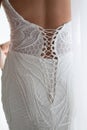 Wedding gown being tied up at back great detail closeup. Bride in wedding dress. Back view Royalty Free Stock Photo