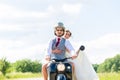 Bridal pair driving motor scooter wearing gown and suit Royalty Free Stock Photo