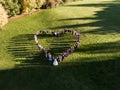 Wedding guests lined up in the shape of heart with bride and groom marriage people