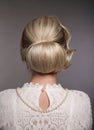 Wedding hairstyle. Portrait of Retro woman with shiny wavy bundle hair, feather in head. Back view of Elegant lady posing isolated