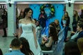 A bride model in a white wedding dress staying among guests