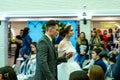 A groom and a bride models in wedding clothes passing the guests