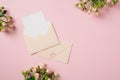 Wedding invitation card template in envelope with rose flowers on pink background. Flat lay, top view, copy space Royalty Free Stock Photo