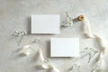 Wedding invitation cards template. Flat lay, top view blank paper cards, ribbon, flower on stone table