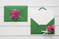 Wedding invitation cards or Valentines Day letters in green envelopes decorated with pink rose flowers. Flat lay. Top view. Royalty Free Stock Photo