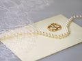 Wedding invitation with a pearl necklace and golden rings Royalty Free Stock Photo