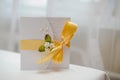 Wedding invitation with yellow satin ribbon and white roses Royalty Free Stock Photo