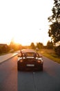 Wedding Just Married sign black rodster cabrio coupe car with bride and groom leaving into sunset in Eastern European