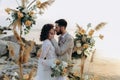 Wedding kiss on the sunset with live floristry. Bride and groom in boho style. Royalty Free Stock Photo