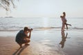 Wedding and lifestyle photographer taking photos of affectionate couple on the beach Royalty Free Stock Photo