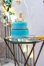 a wedding light blue frosting cake on the glass table