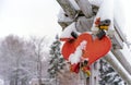 Wedding locks and wedding hearts covered with snow on the parapet of the bridge over the frozen river in a small Russian town in Royalty Free Stock Photo