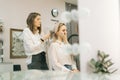 Wedding makeup artist making fashion make-up for beautiful bride in lighting dressing room. Royalty Free Stock Photo