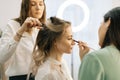 Wedding makeup artist making fashion make-up for beautiful bride in lighting dressing room. Royalty Free Stock Photo