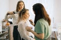 Wedding makeup artist making fashion make-up for beautiful bride in lighting dressing room. Royalty Free Stock Photo