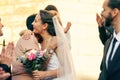 Wedding, marriage and bride hug family guests with a smile while leave church with groom after marrying, celebration and