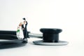 Wedding marriage and couple medical check-up concept miniature people toy photography. Bride and groom with stethoscope isolated