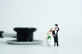 Wedding marriage and couple medical check-up concept miniature people toy photography. Bride and groom with stethoscope 