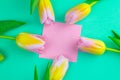 Wedding mockup with pink paper list and tulip flowers on green table top view. Beautiful floral pattern. Flat lay style Royalty Free Stock Photo