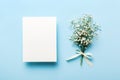 Wedding mockup with white paper list and flowers gypsophila on colored table top view flat lay. Blank greeting cards and Royalty Free Stock Photo