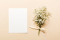 Wedding mockup with white paper list and flowers gypsophila on colored table top view flat lay. Blank greeting cards and Royalty Free Stock Photo