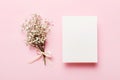 Wedding mockup with white paper list and flowers gypsophila on colored table top view flat lay. Blank greeting cards and Royalty Free Stock Photo