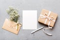 Wedding mockup with white paper list and flowers gypsophila on colored table top view flat lay. Blank greeting cards and Royalty Free Stock Photo