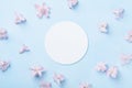 Wedding mockup with white paper list and pink flowers on blue table from above. Beautiful floral pattern. Flat lay style. Royalty Free Stock Photo