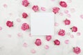 Wedding mockup with white paper list, pink rose flowers and petals on light table top view. Beautiful floral pattern. Flat lay Royalty Free Stock Photo