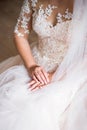 Wedding morning of the bride. Hands close-up with a gold ring. Wedding manicure close-up. White veil in hand, against the Royalty Free Stock Photo