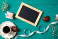 Wedding morning concept. Blank photo frame, heart-shaped chocolate, gift box, ribbon, cup of coffee, daisy flowers. Stylish
