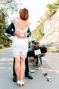 Wedding, newlyweds. Hugs and kisses of a man and a woman in wedding dresses. There is a motorcycle in the background. Summer.