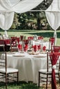 Wedding outdoor reception - round table with white table cloths, golden plates, rustic wooden centerpieces and black candle Royalty Free Stock Photo