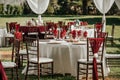 Wedding outdoor reception - round table with white table cloths, golden plates, rustic wooden centerpieces and black candle Royalty Free Stock Photo