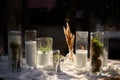 Wedding party banquet outdoors in forest. Dining table decorated in boho style with candles, white cloth, flowers