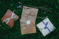 Wedding or party decorative envelopes lie on the green grass. Ivory, brown and violet colours. Strings and lavender. Rustic