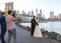 BROOKLYN, NYC - OCTOBER 08, 2019: Wedding photo shoot in Brooklyn Bridge Park in NYC. Bride and Groom with Photographer and