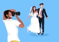 Wedding photographer shooting on camera newlyweds man woman couple posing together man taking professional photo Royalty Free Stock Photo