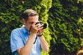 wedding photographer takes pictures of bride and groom in city. wedding couple on photo shoot. photographer in action. Royalty Free Stock Photo