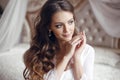 Wedding Portrait of Beautiful Bride girl smiling. Brunette with makeup and long curly hair style wearing in white sexy boudoir Royalty Free Stock Photo