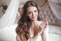 Wedding Portrait of Beautiful Bride girl smiling. Brunette with makeup and long curly hair style wearing in white sexy boudoir Royalty Free Stock Photo